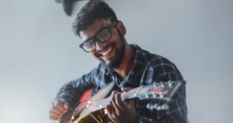 Self love in addiction recovery, man taking time to play guitar