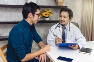 A man speaking with a doctor asking how long is php treatment.
