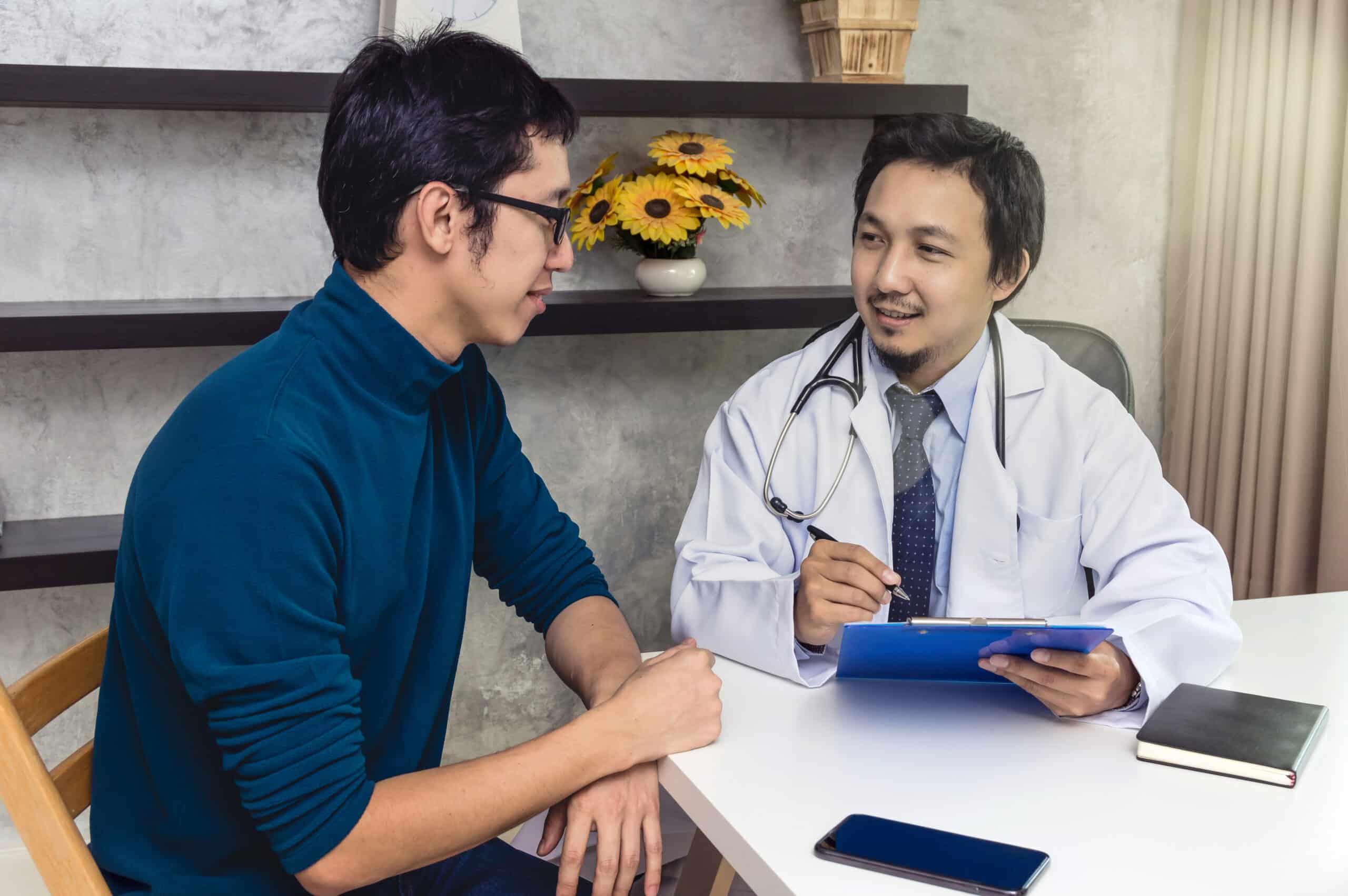 A man speaking with a doctor asking how long is php treatment.