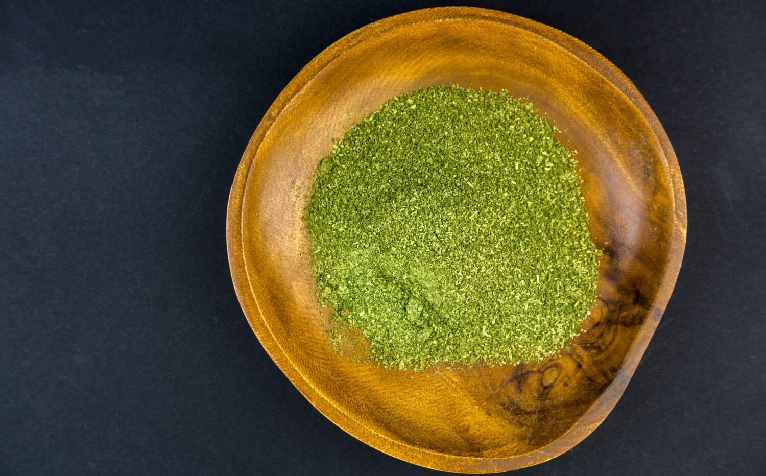 wooden bowl full of green dried herbs 2026 01 07 00 19 39 utc scaled e1781123157350