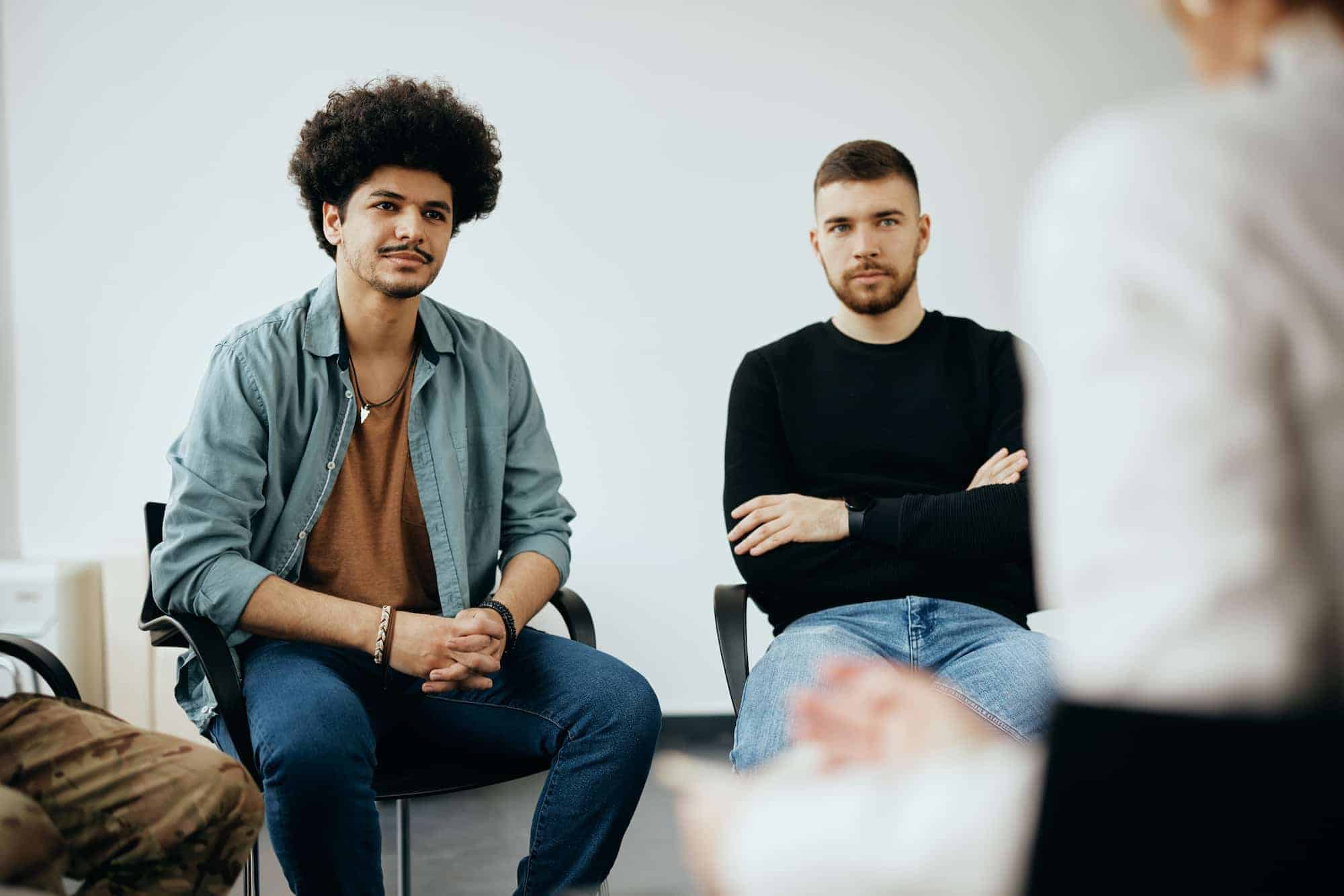 Men listening during a group therapy session in an intensive outpatient program