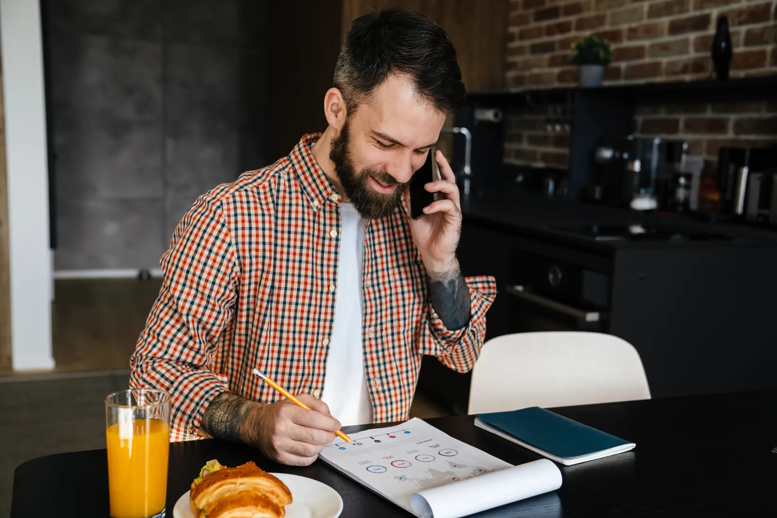 Man on a phone call reviewing paperwork while verifying his BCBS insurance benefits